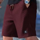 Men wearing lightweight casual sports shorts with drawstring waistband and side pockets for summer activewear