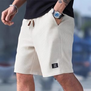 Men wearing lightweight casual sports shorts with drawstring waistband and side pockets for summer activewear