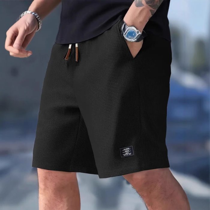 f3a773ae-c1ea-4fbe-91e3-30e57f0a294c-3.jpg Men wearing lightweight casual sports shorts with drawstring waistband and side pockets for summer activewear
