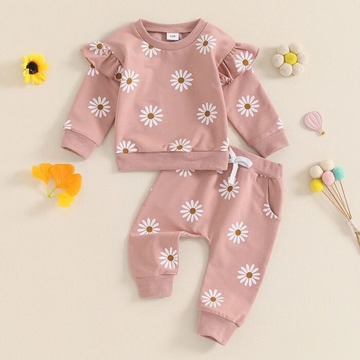 Cute toddler wearing a cozy baby girl floral outfit with a daisy print long-sleeve top and matching pants.