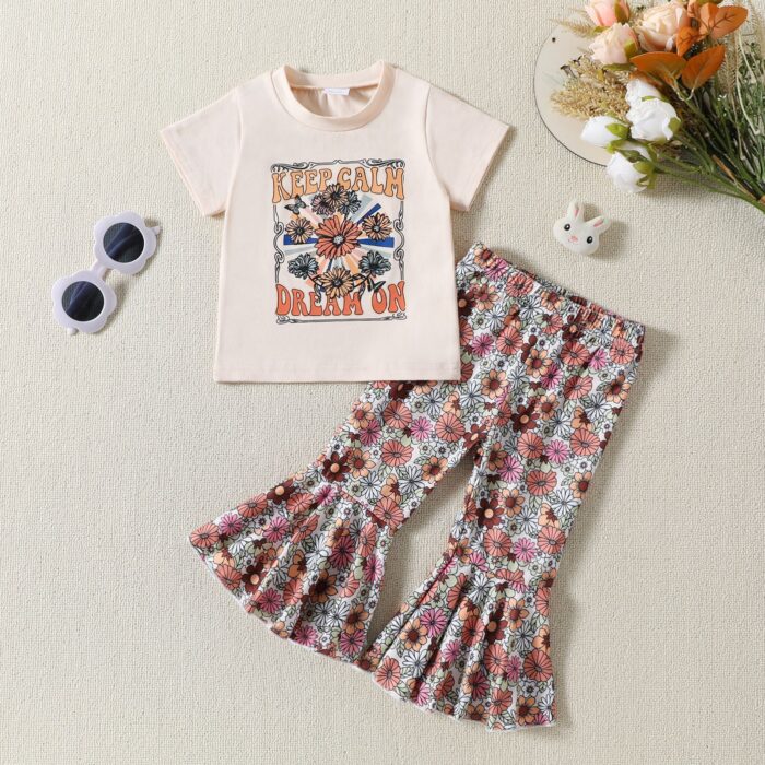 0bffdca8-a248-4b00-b463-bfd608e5b490.jpg Cute toddler girl smiling and wearing a trendy toddler girl bell bottom outfit with a floral print.