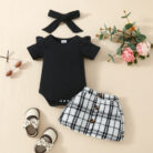 Happy baby girl wearing a stylish baby girl plaid skirt set with a matching headband.
