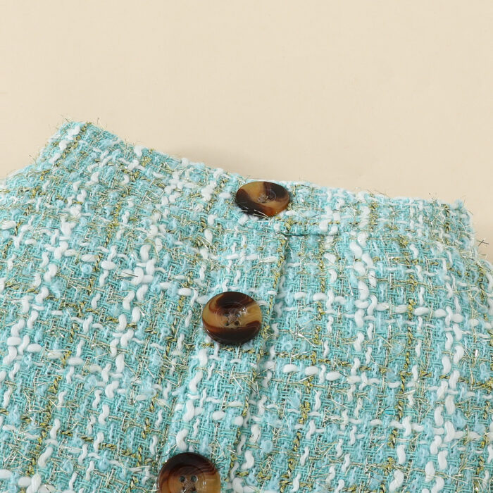 Happy baby girl wearing a stylish baby girl plaid skirt set with a matching headband.