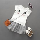Young girl smiling and twirling in an adorable girls cat print skirt set.