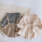 Adorable baby girl wearing a trendy boho baby girl suspender romper.