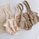 Adorable baby girl wearing a trendy boho baby girl suspender romper.
