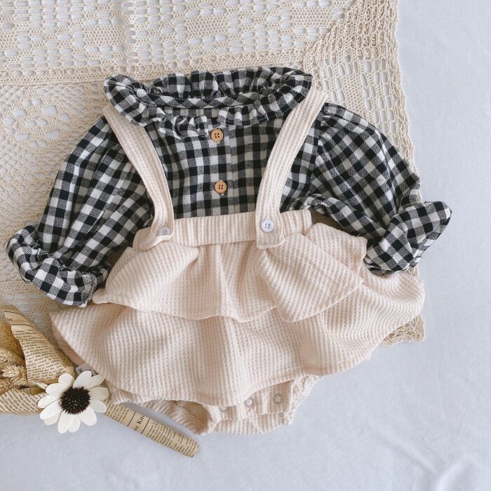 Adorable baby girl wearing a trendy boho baby girl suspender romper.