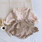 Adorable baby girl wearing a trendy boho baby girl suspender romper.