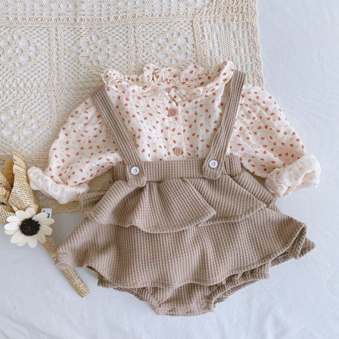 Adorable baby girl wearing a trendy boho baby girl suspender romper.