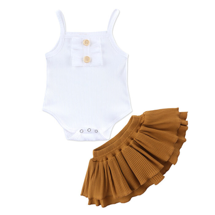 Baby girl smiling in a beautifully soft baby girl romper and skirt set.