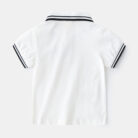 Young boy smiling outdoors wearing a comfortable boys short sleeve summer polo.