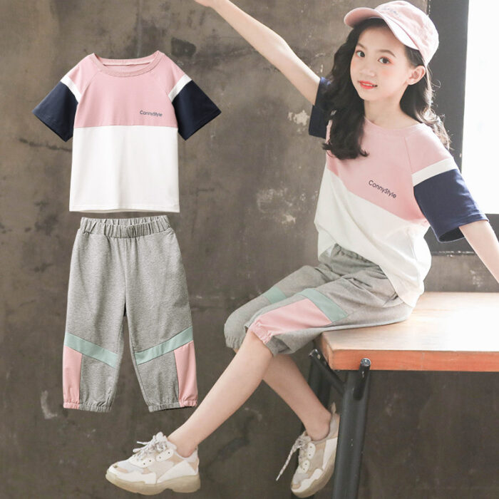 1623475056442.jpg Older child smiling outdoors wearing a trendy pink kids sporty two piece set.