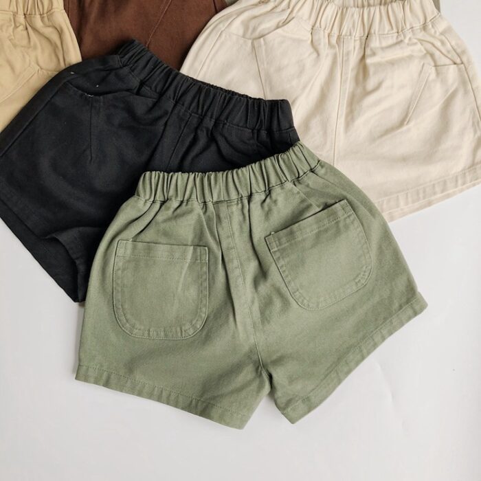 1752428184799-1.jpg Young child playing outdoors wearing vibrant kids candy color shorts.