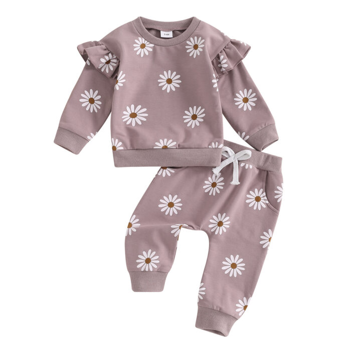 Cute toddler wearing a cozy baby girl floral outfit with a daisy print long-sleeve top and matching pants.