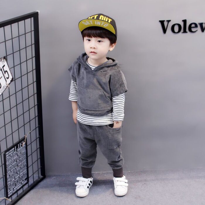 Handsome toddler boy smiling in a stylish boys 3 piece hoodie terno set.