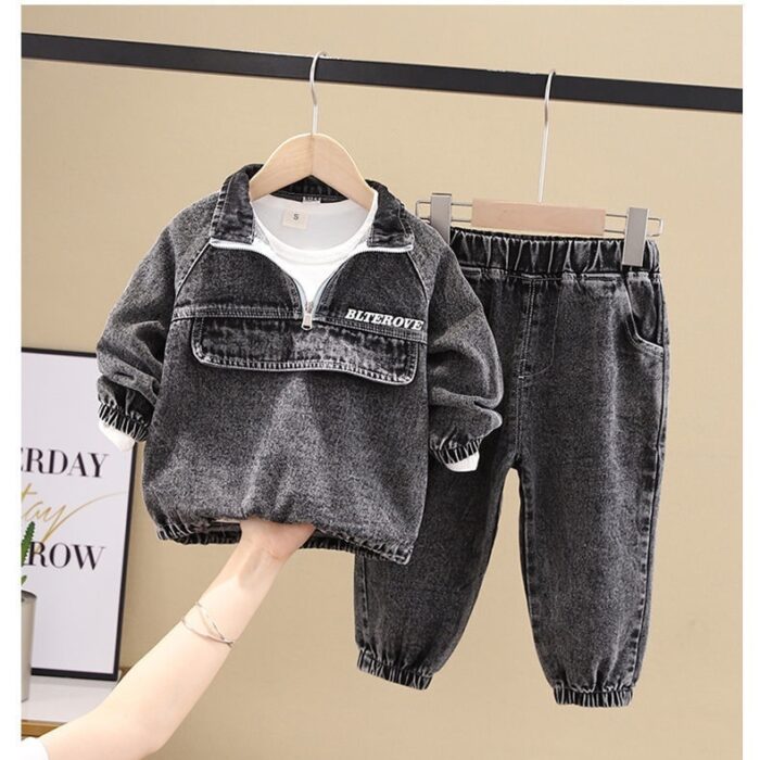 Stylish little boy smiling outdoors in a cool boys denim terno set.