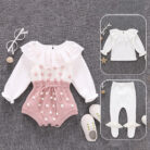 Cute baby girl wearing a cozy, minimalist baby girl long sleeve romper.