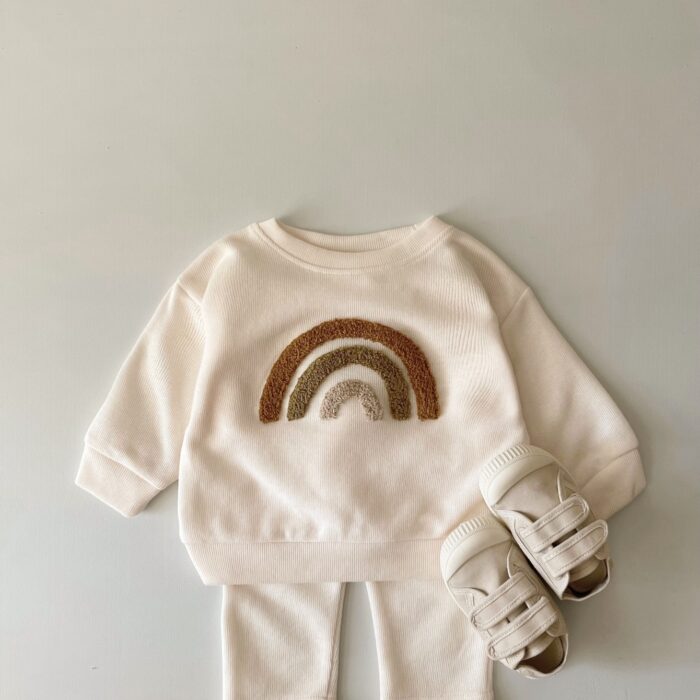 2b6b20f5-276d-4522-87f2-95f8c2365f27.jpg Cute baby wearing a neutral creamy-white baby embroidered two piece outfit.