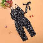 Young girl smiling outdoors wearing a stylish girls polka dot jumpsuit.