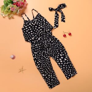 Young girl smiling outdoors wearing a stylish girls polka dot jumpsuit.