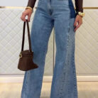 Woman wearing stylish women's high waisted flare jeans in a light blue wash.