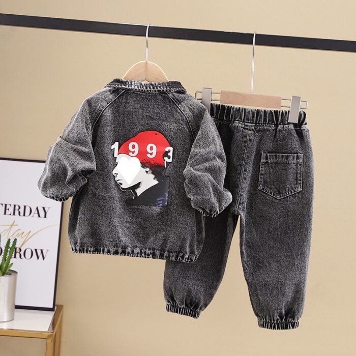 Stylish little boy smiling outdoors in a cool boys denim terno set.