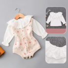 Cute baby girl wearing a cozy, minimalist baby girl long sleeve romper.