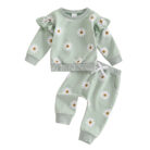 Cute toddler wearing a cozy baby girl floral outfit with a daisy print long-sleeve top and matching pants.