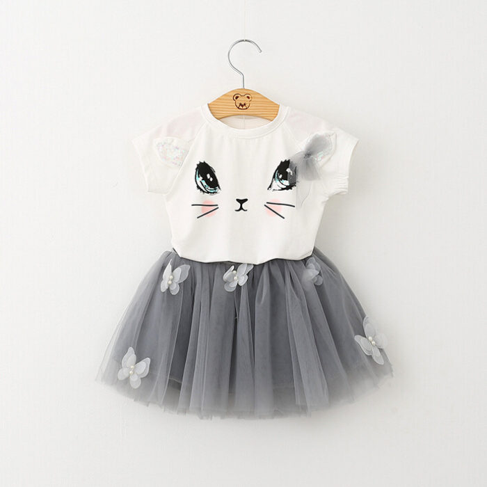 Young girl smiling and twirling in an adorable girls cat print skirt set.