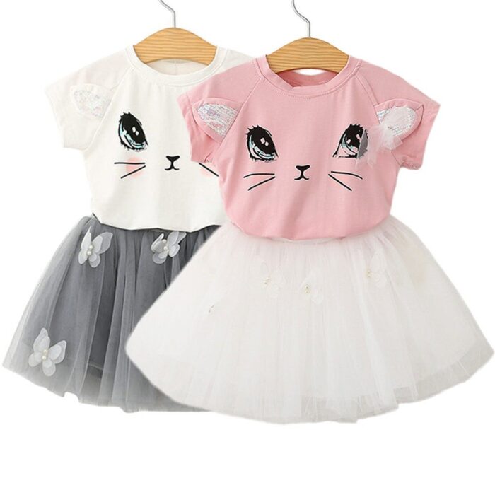 Young girl smiling and twirling in an adorable girls cat print skirt set.