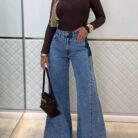Woman wearing stylish women's high waisted flare jeans in a light blue wash.