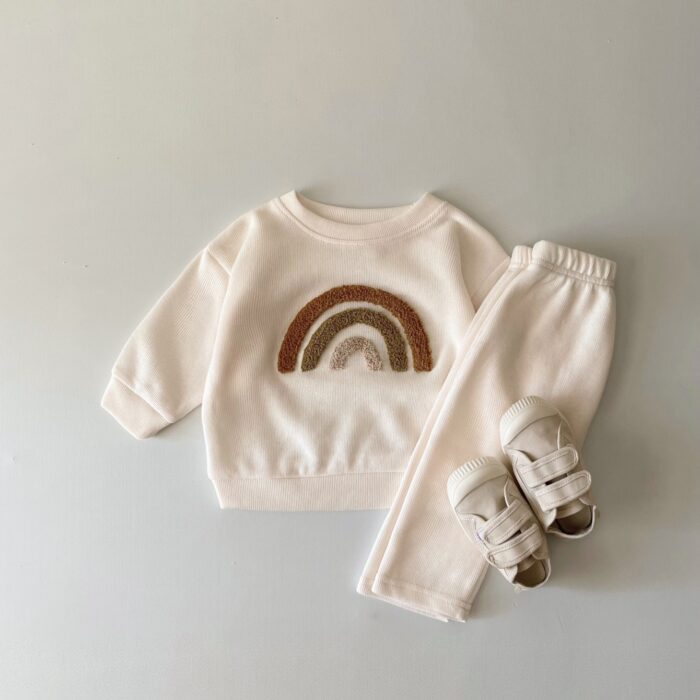 5aaf8770-26c1-4878-9234-18577cdeebf2.jpg Cute baby wearing a neutral creamy-white baby embroidered two piece outfit.