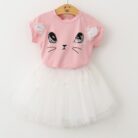 Young girl smiling and twirling in an adorable girls cat print skirt set.
