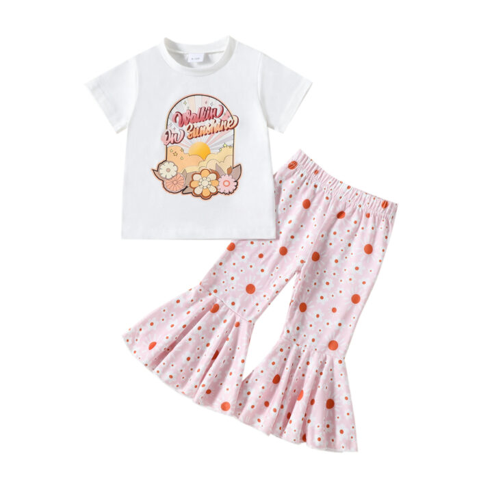 6a5b9e4b-472a-41ca-aec7-4f4581b4c82e.jpg Cute toddler girl smiling and wearing a trendy toddler girl bell bottom outfit with a floral print.