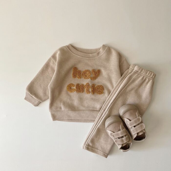 7b8bfbeb-6161-4c13-8ae9-059efc3d2282.jpg Cute baby wearing a neutral creamy-white baby embroidered two piece outfit.