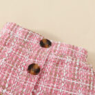 Happy baby girl wearing a stylish baby girl plaid skirt set with a matching headband.