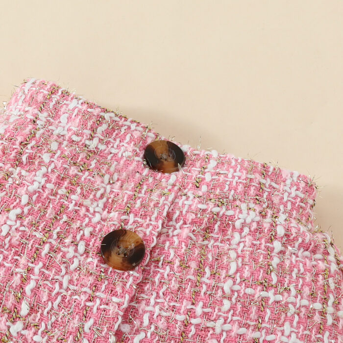 Happy baby girl wearing a stylish baby girl plaid skirt set with a matching headband.