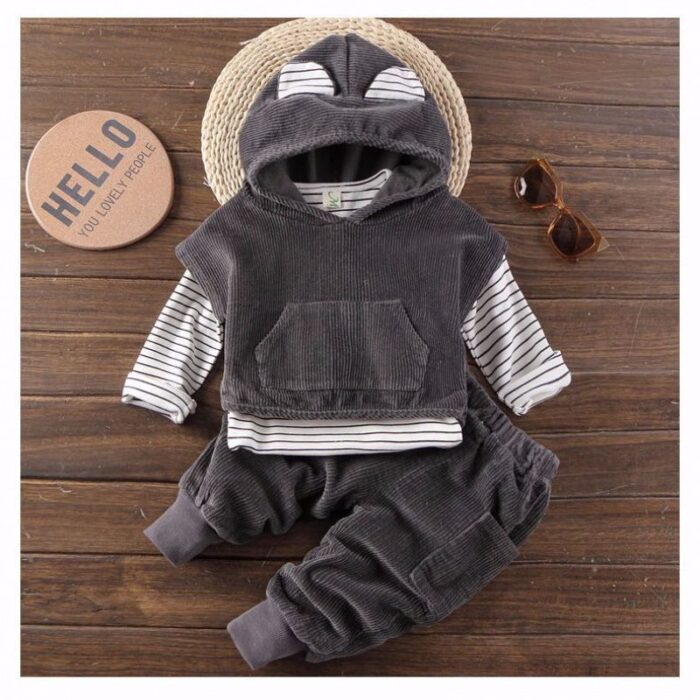 Handsome toddler boy smiling in a stylish boys 3 piece hoodie terno set.