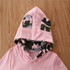 Stylish toddler girl smiling outdoors in a trendy pink toddler girl camo outfit.