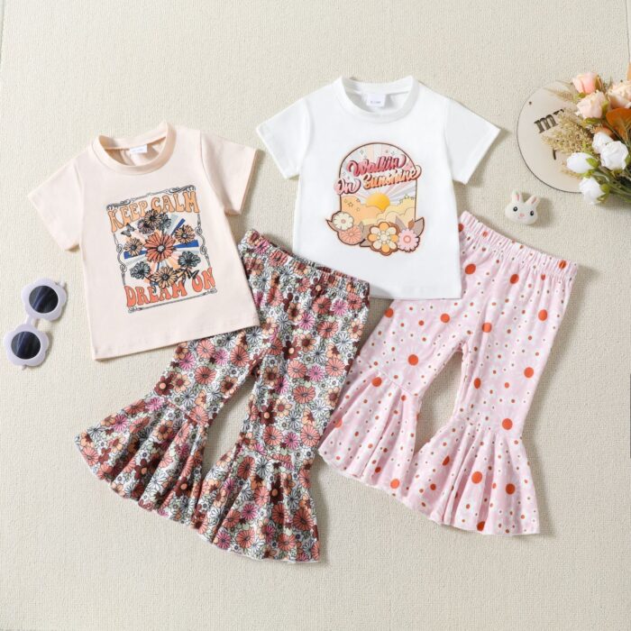 b8d3140b-9a5d-45b0-882b-30a3550ce976.jpg Cute toddler girl smiling and wearing a trendy toddler girl bell bottom outfit with a floral print.