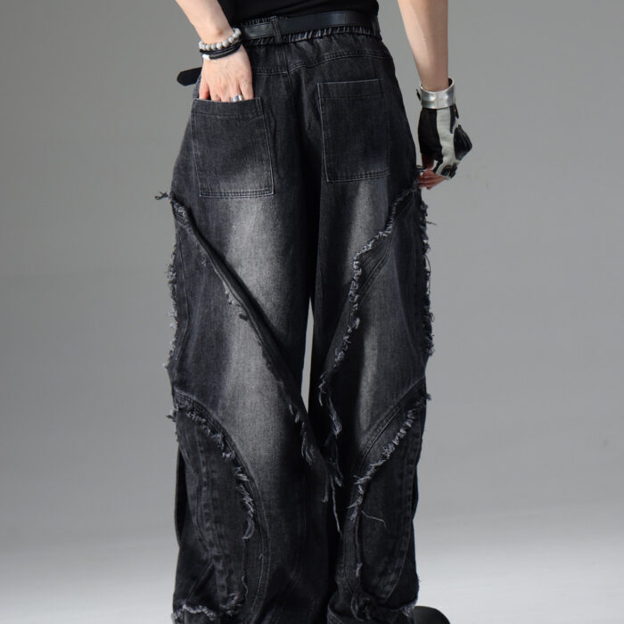 Young man wearing stylish black mens vintage distressed drawstring jeans.
