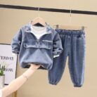 Stylish little boy smiling outdoors in a cool boys denim terno set.