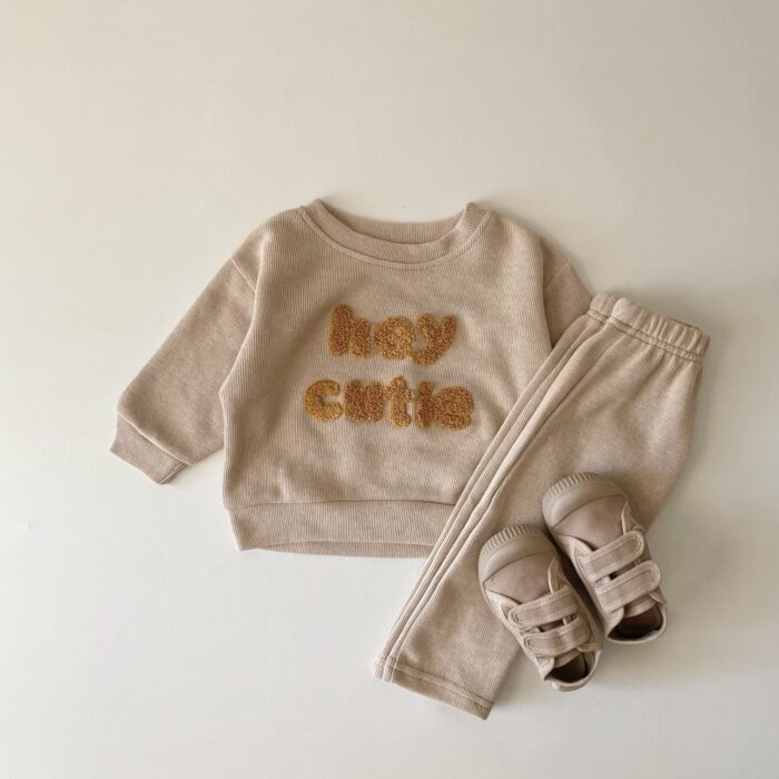d22e0b82-e7d8-4c78-a819-fb7000756c4d.jpg Cute baby wearing a neutral creamy-white baby embroidered two piece outfit.
