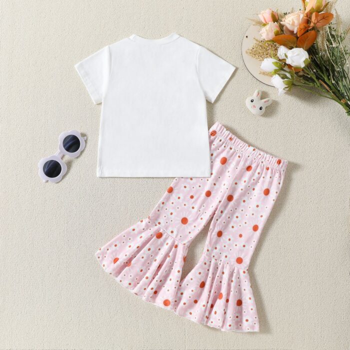 d539973c-2e04-4fd4-977d-e79d24bb4744.jpg Cute toddler girl smiling and wearing a trendy toddler girl bell bottom outfit with a floral print.