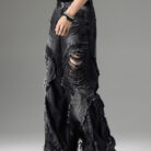 Young man wearing stylish black mens vintage distressed drawstring jeans.