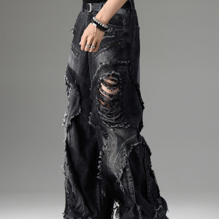 Young man wearing stylish black mens vintage distressed drawstring jeans.