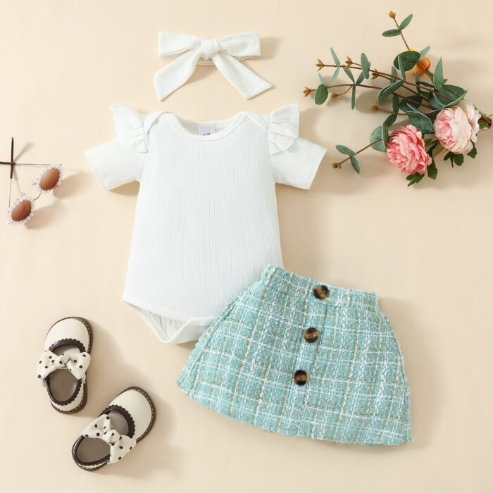Happy baby girl wearing a stylish baby girl plaid skirt set with a matching headband.