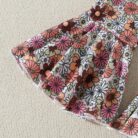 Cute toddler girl smiling and wearing a trendy toddler girl bell bottom outfit with a floral print.