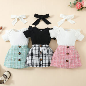 Happy baby girl wearing a stylish baby girl plaid skirt set with a matching headband.