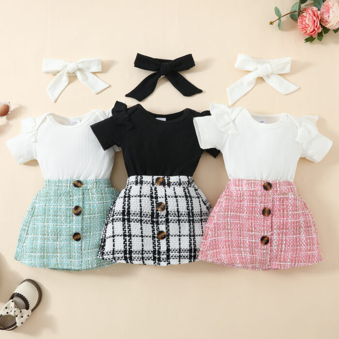 Happy baby girl wearing a stylish baby girl plaid skirt set with a matching headband.